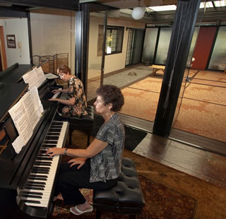 Carol Swenson (background) and piano partner Marsha Rocklin (foreground) love to entertain from Carol's loggia to crowds seated in her adjacent atrium.
