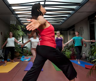 Prabha Gopal (in red) leads students during a session of “serious, classical yoga” in her Walnut Creek Eichler.