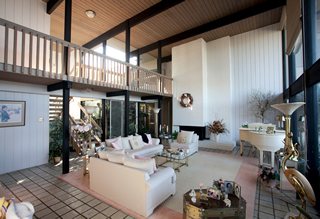 The large, open living room of Gail and Ronald Miller draws your eye to the dramatic overhanging balcony above. 